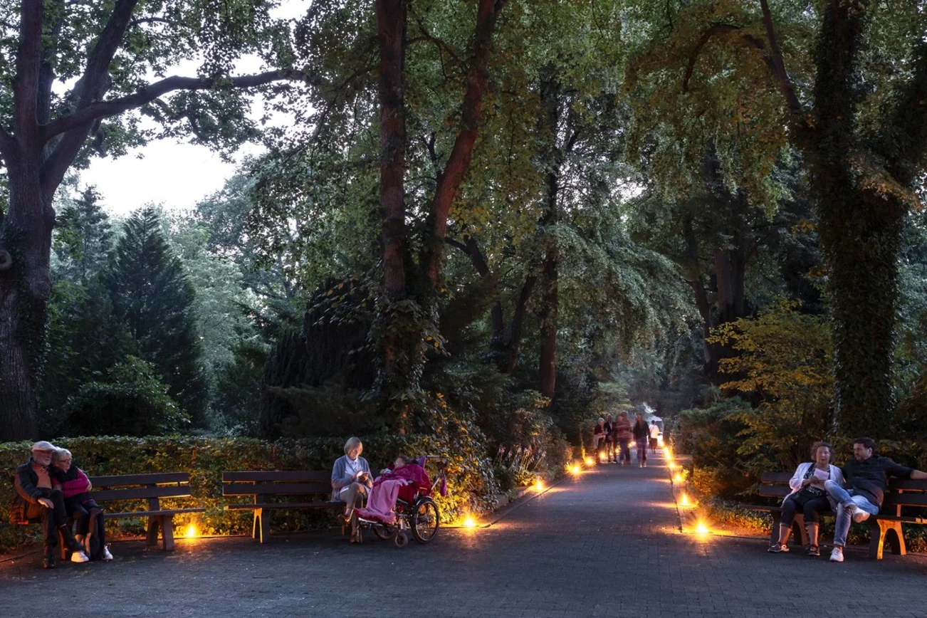 Mit Kerzen erleuchteter Weg auf einem Friedhof