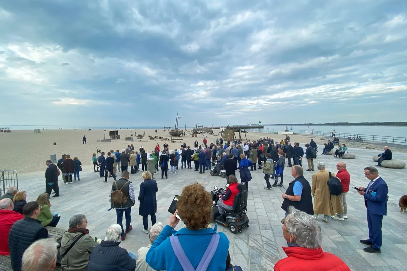 Menschen feiern Abendmahl am Strand. 