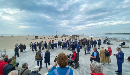 Menschen feiern Abendmahl am Strand. 