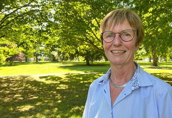 Eine Frau steht in einem sommerlich grünenden Park - Copyright: Bastian Modrow