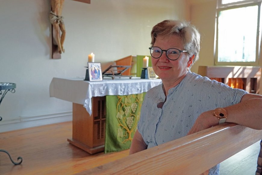 Eine Frau mit Brille und kurzen Haaren sitzt in einer kleinen Kapelle. - Copyright: Annkathrin Bornholdt