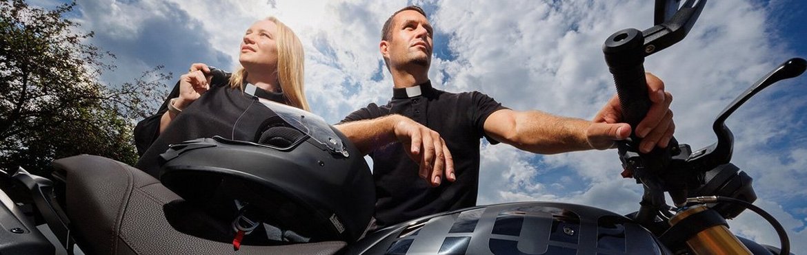 Pfarrerin und Diakon stehen am Motorrad