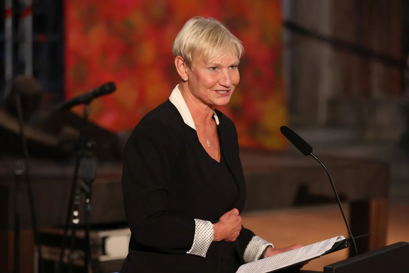 Eine Frau mit kurzen blonden Haaren steht an einem Rednerpult