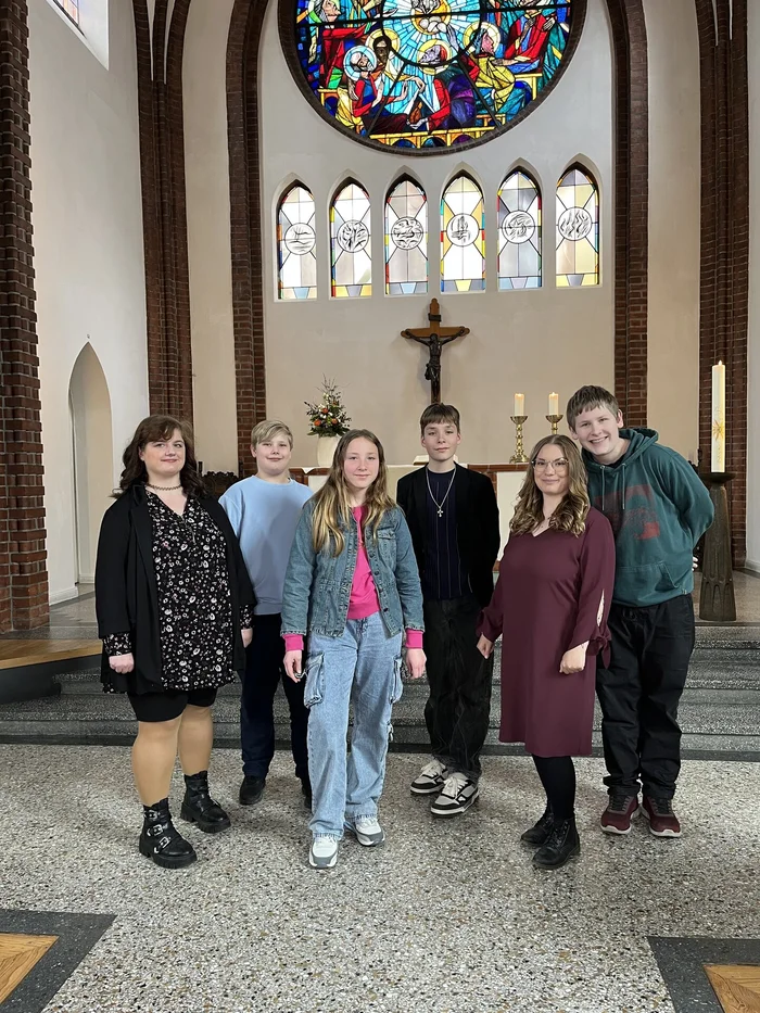 Sechs junge Menschen stehen im Altarraum einer Kirche.