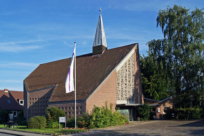 Außenansicht der Dietrich-Bonhoeffer-Kapelle - Copyright: Manfred Maronde Kapelle über Eck in Abendsonne, links Fahrrad am Schaukasten, in Mitte Kreuz-Hochfahne, rechts Birke mit Schatten - Copyright: Manfred Maronde