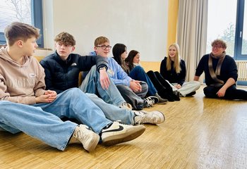 Jugendliche und der Pastor sitzen auf dem Boden und unterhalten sich - Copyright: Mathias Stanierowski