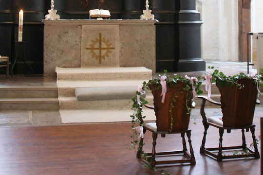 geschmückte Holzstühle in der Kirche vor dem Altar