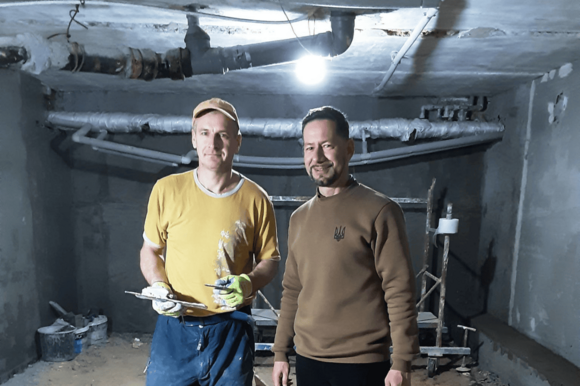 Zwei Männer und Kinder sitzen an einem bunt gedeckten Tisch und essen