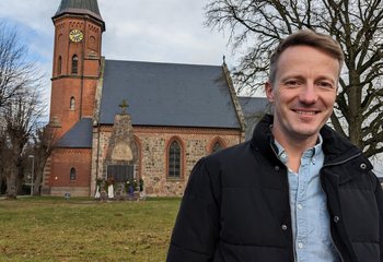 Ein Mann steht vor einer Kirche - Copyright: Oliver Pries