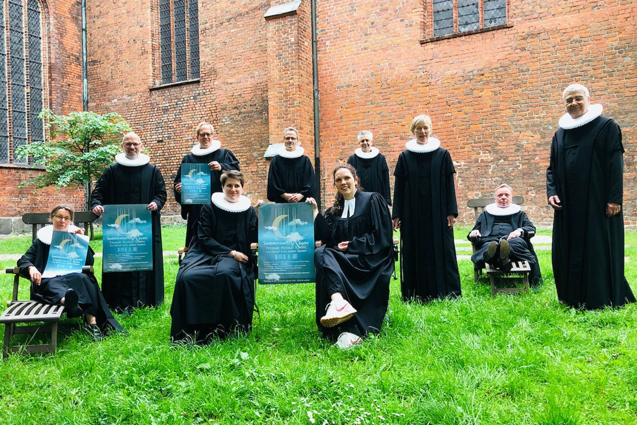 Die Innenstadtpastoren mit dem Plakat für "Sommernachtsräume".