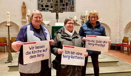 Drei Frauen halten jeweils ein A3 Promotion-Plakat vor sich.