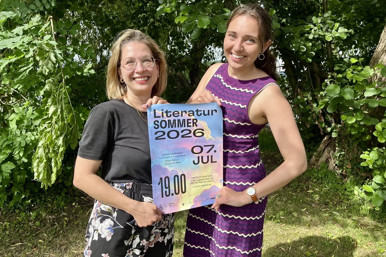 Zwei Frauen halten ein Plakat fest