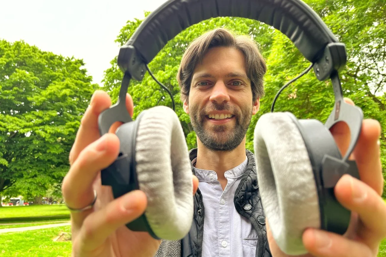 Ein Mann hält Kopfhörer in den Händen