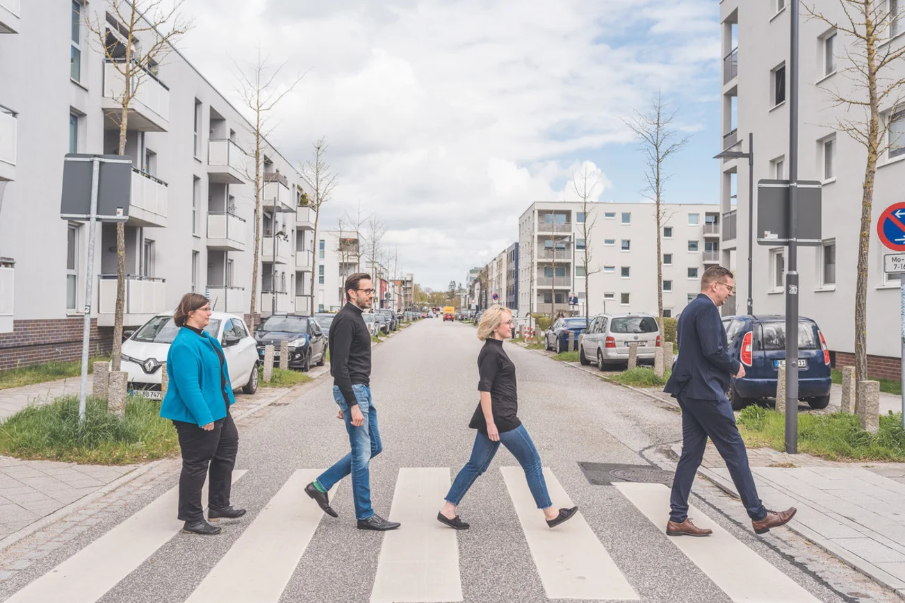 Eine Gruppe von menschen passiert eine Straße. 