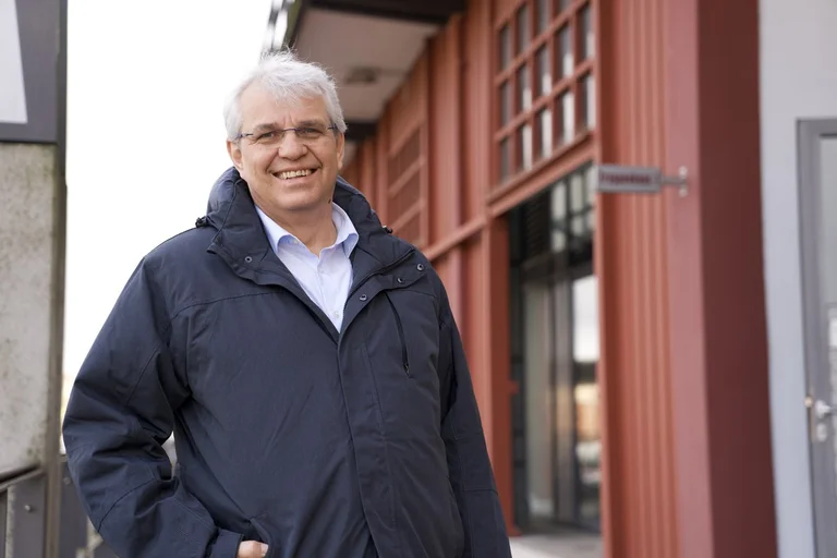 Ein Mann steht vor einem Haus 