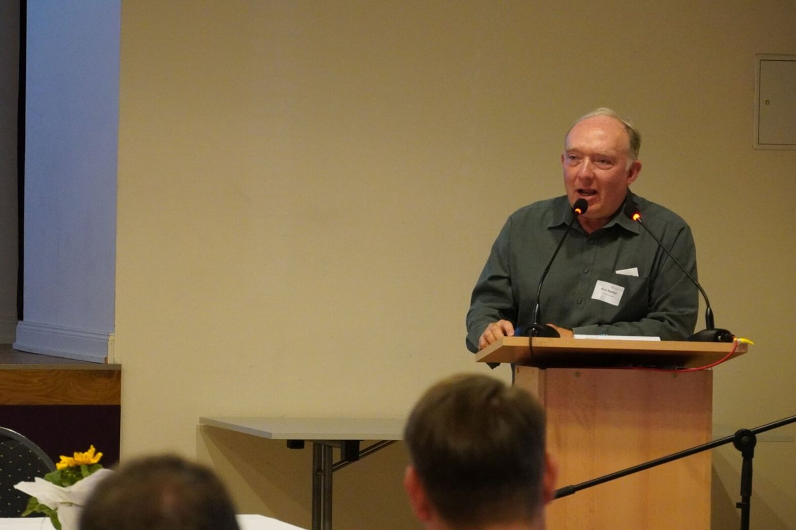 Ein Mann steht an einem Rednerpult. 