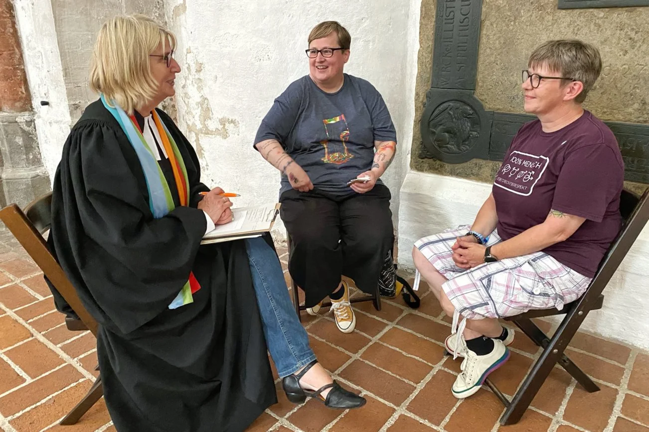 Drei Frauen unterhalten sich in einer Kirche