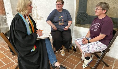 Drei Frauen unterhalten sich in einer Kirche