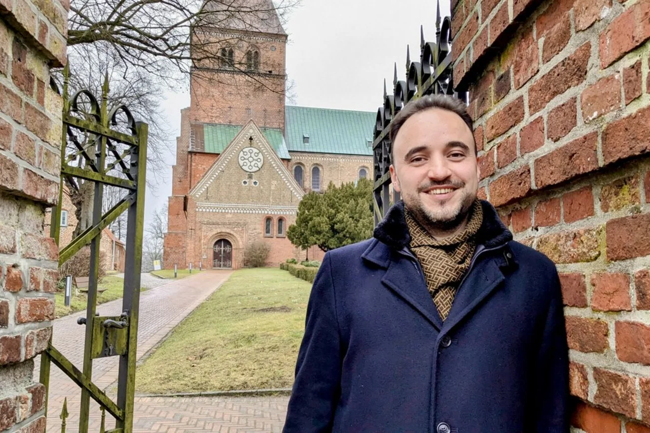 Ein Mann steht vor einer Kirche