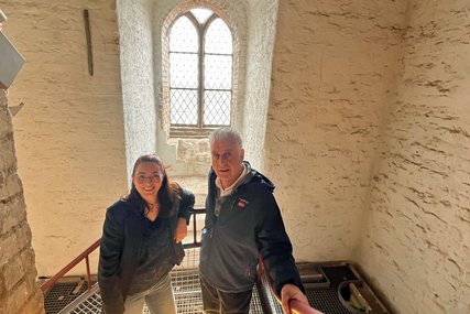 Eine Frau und ein Mann stehen im Treppenhaus einer Kirche - Copyright: Daniel Sorour