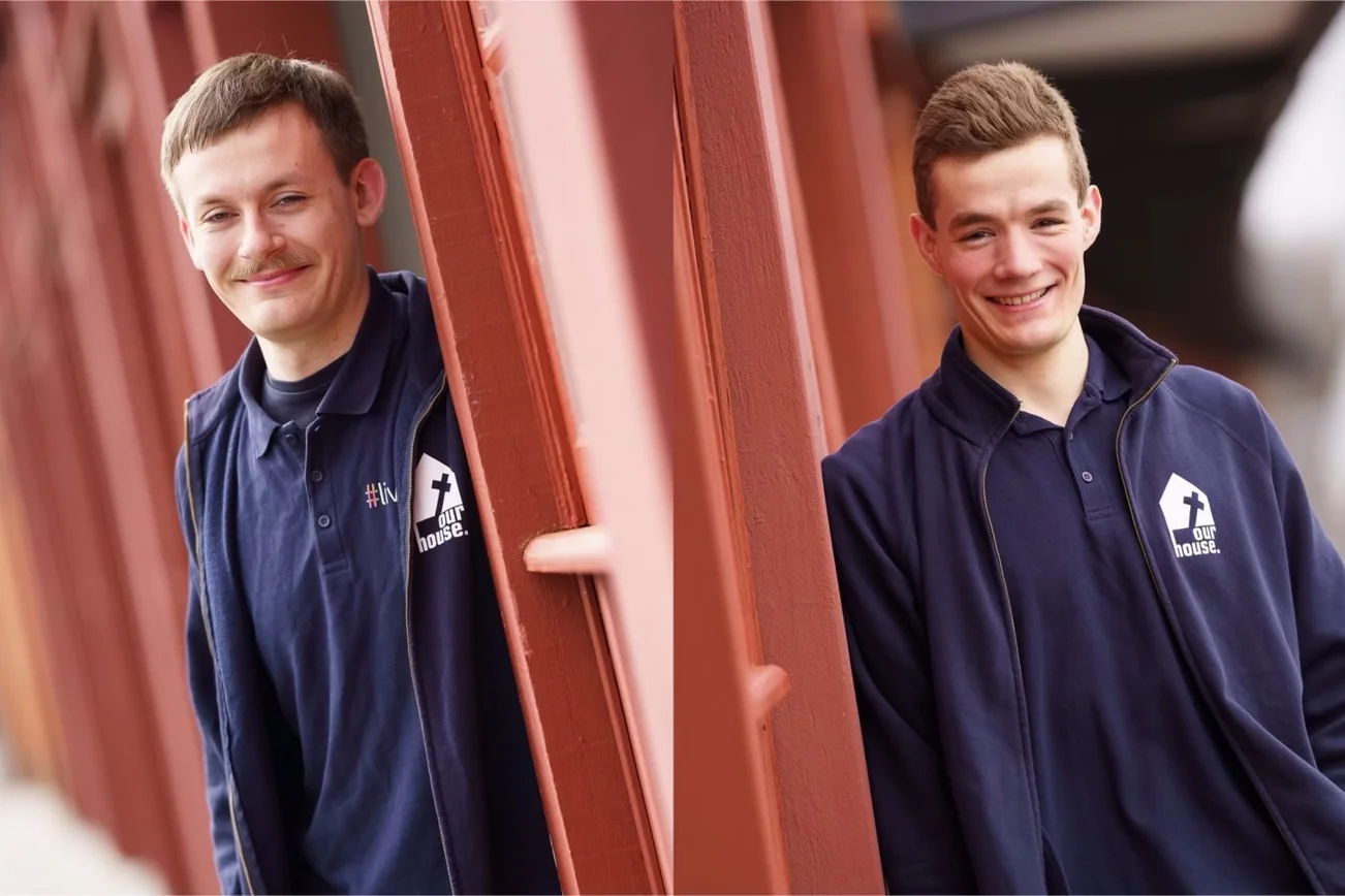 Zwei junge Männer blicken in die Kamera. 