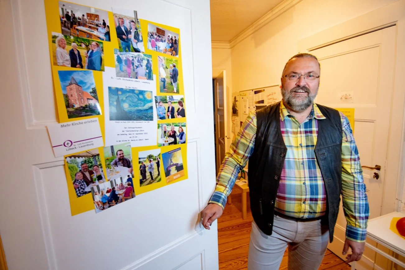 Ein Mann steht lächelnd in einem Raum