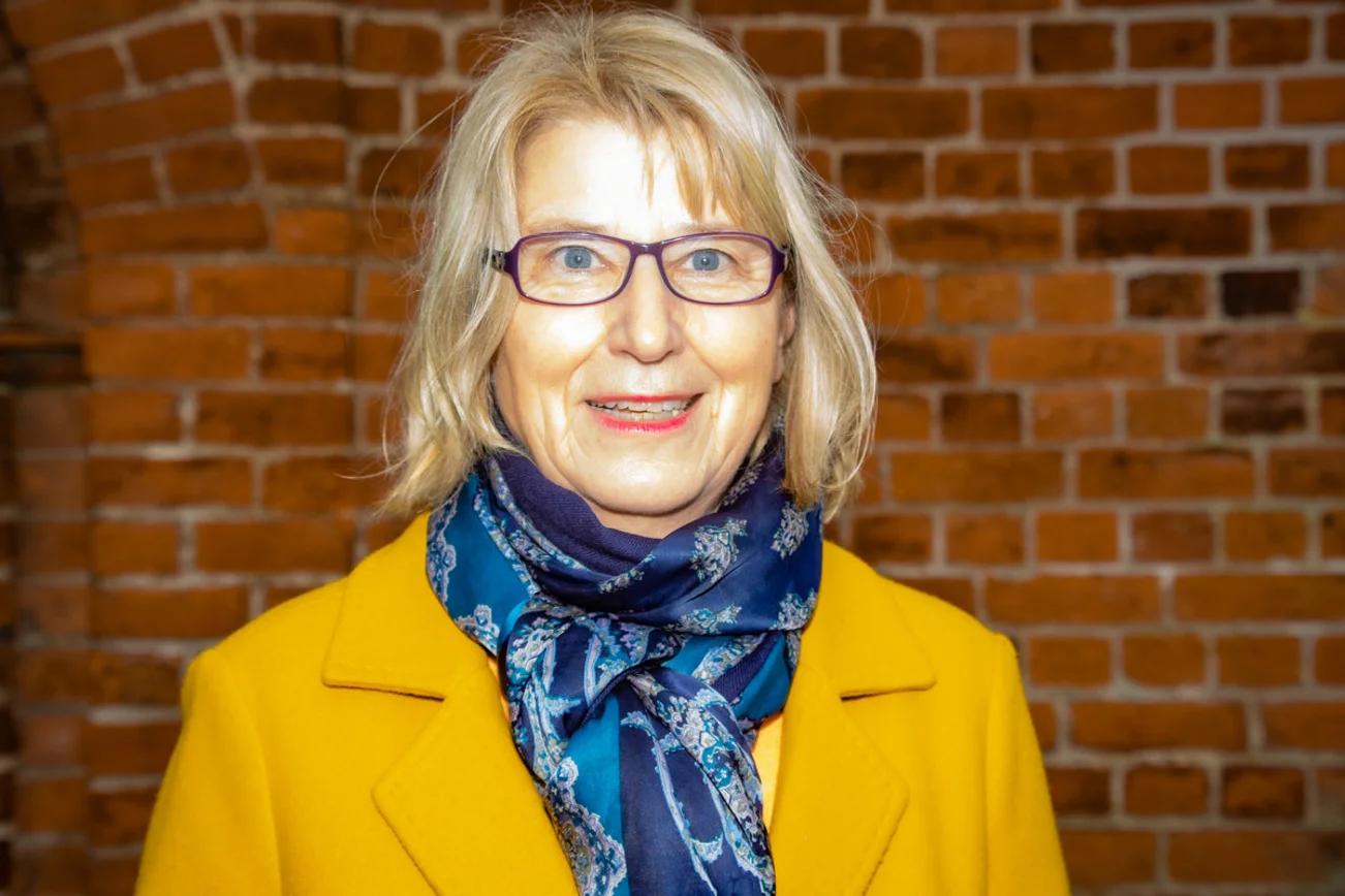 Eine Frau schaut lächelnd in die Kamera. 