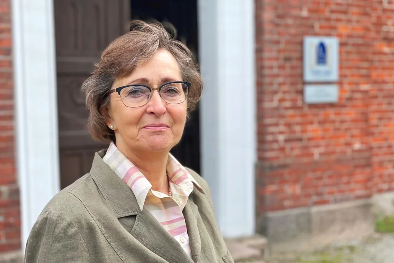 Frau steht vor einer Kirche