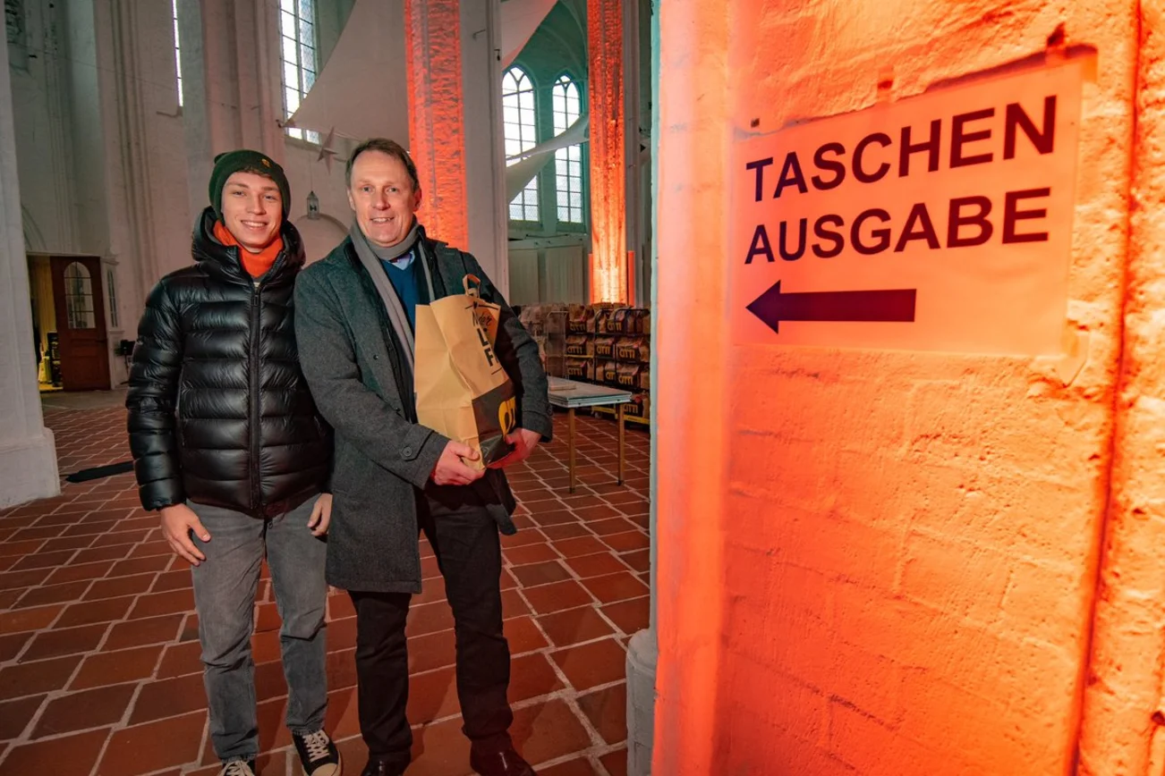 Zwei Personen stehen in St. Petri und lächeln in die Kamera. 
