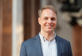 Ein Man mit blauem Sacko und kurzen blonden Haaren lächelt in die Kamera. - Copyright: Oliver Beck
