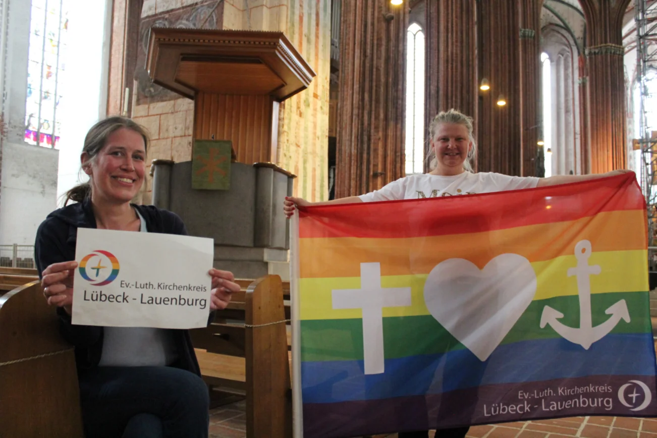 Zwei Frauen in St. Marien mit Regenbogen-Flagge.