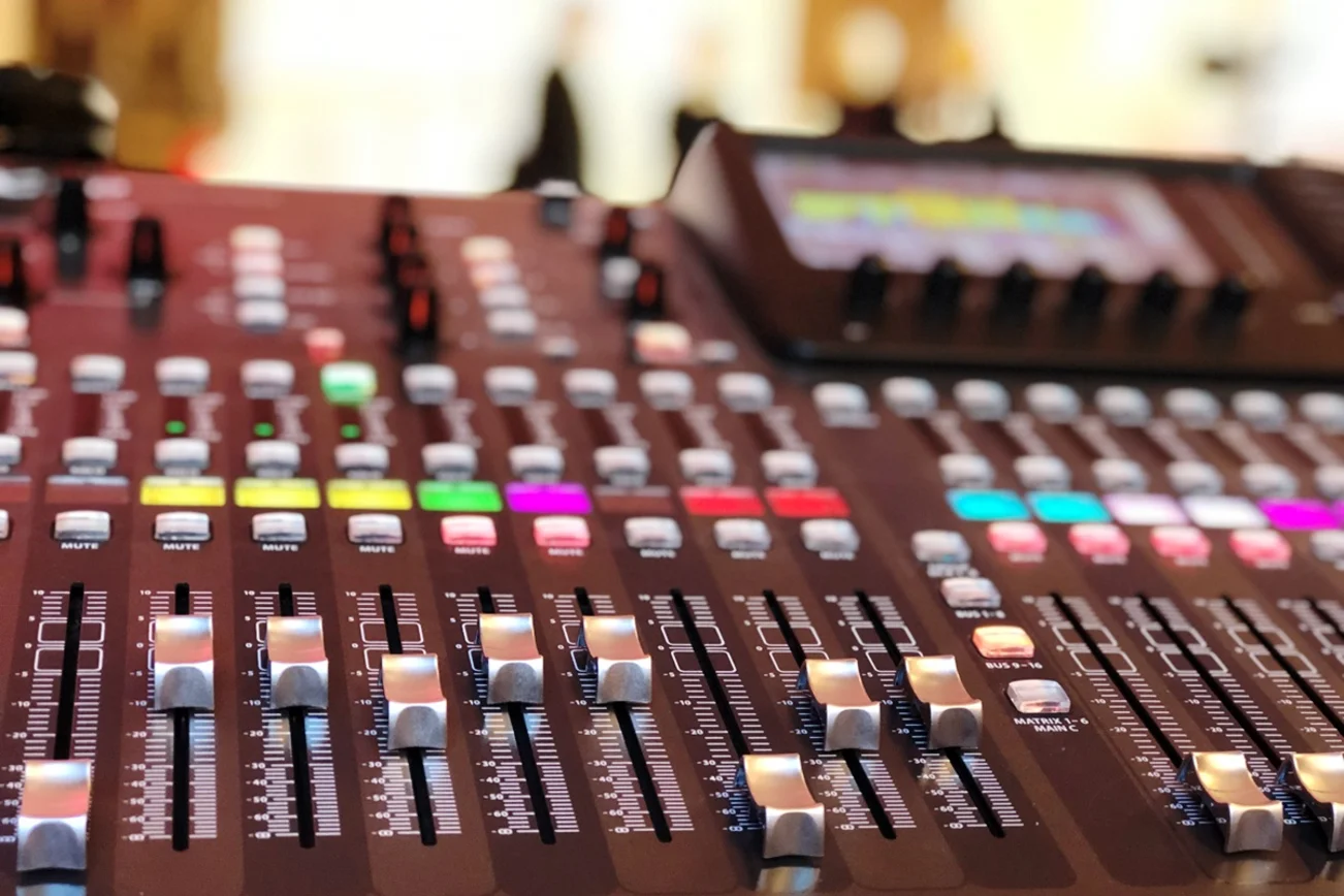 Ein Mischpult mit Reglern und bunten Knöpfen.