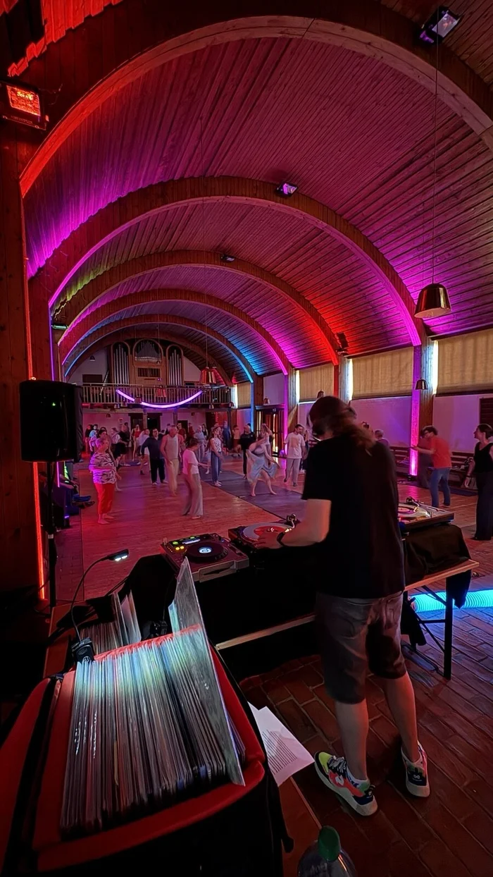 Kirchenschiff mit Partybeleuchtung, DJ und Tanzenden