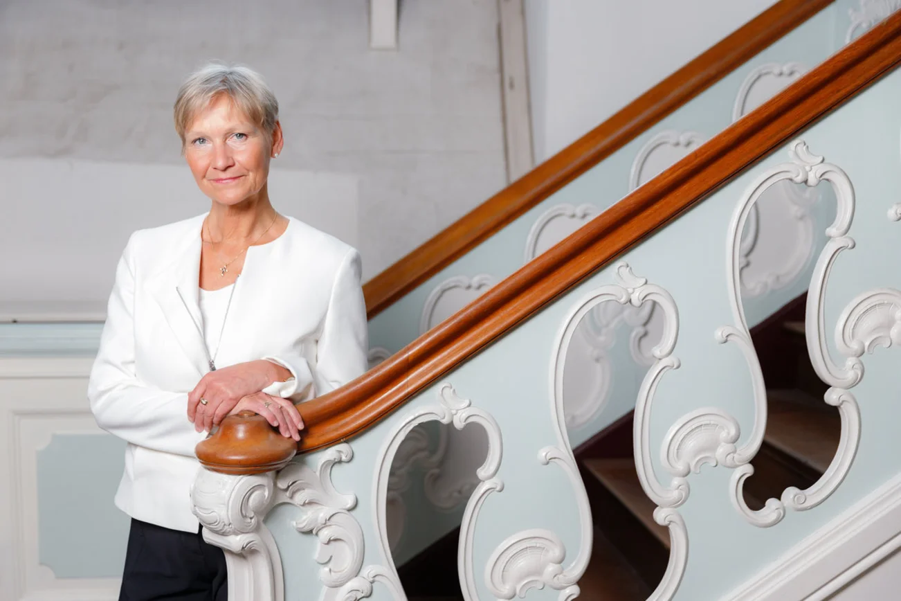 Eine Frau steht an einer Treppe.