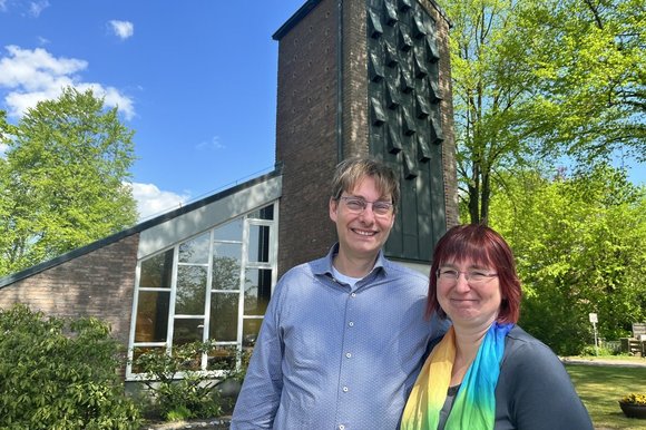 Zwei Personen vor einer Kirche