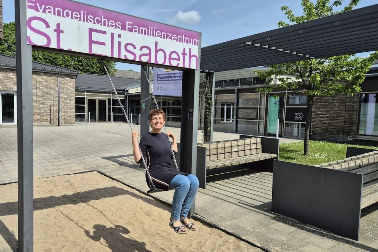 Pastorin Kühn auf einer Schaukel vor dem Familienzentrum Schwarzenbek