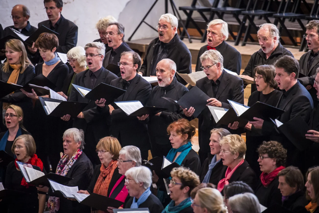 Mehrere Chorsängerinnen und -sänger während eines Auftritts.