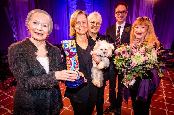 Personen stehen mit einer Skulptur und einem Hund in einer Kirche