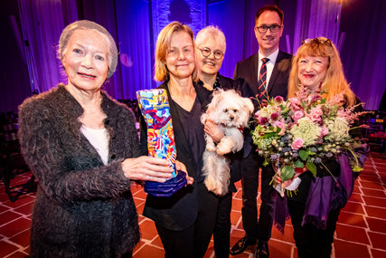 Personen stehen mit einer Skulptur und einem Hund in einer Kirche - Copyright: Lena Modrow 