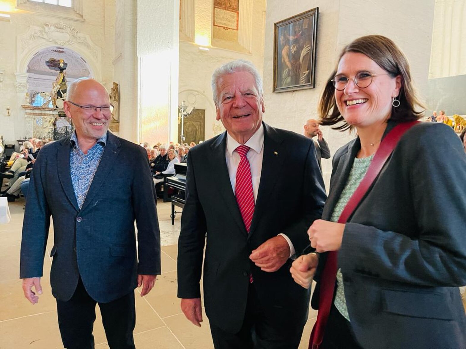 Drei Personen in einer Kirche.