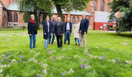 v. li.: Dr. Cornelia Schäfer, Dompastorin Margrit Wegner, Architekt Jürgen Rösing, Bauabteilung Kirchenkreis Lübeck-Lauenburg, Dompastor Martin Klatt, Carlos Blohm, Vorsitzender des Dom-Bauausschusses, Heike Reimann, Fundraiserin im Sieben-Türme-Projekt und Titus Jochen Held, Stiftungsvorstand der Gemeinnützigen Sparkassen-Stiftung zu Lübeck. Sie stehen vor dem Dom zu lübeck auf der Rasenfläche zweireihig nebeneinander