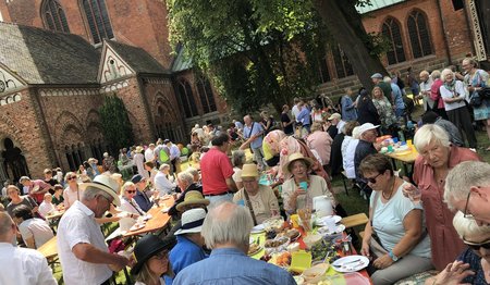 Blick auf Menschen vor einer Kirche