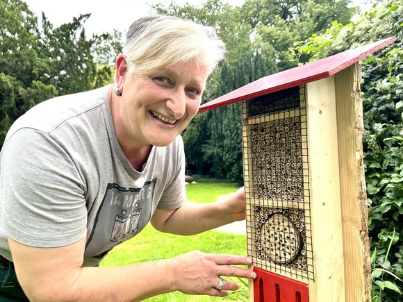 Eine Frau zeigt ein Insektenhotel