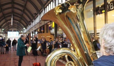 Ein Posaunenchor spielt in der Bahnhofshalle Lübeck