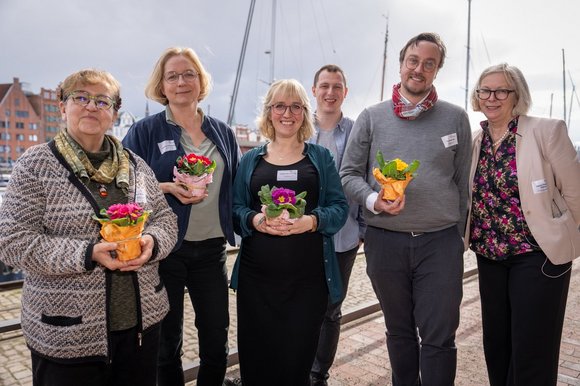 Menschen vor maritimer Kulisse