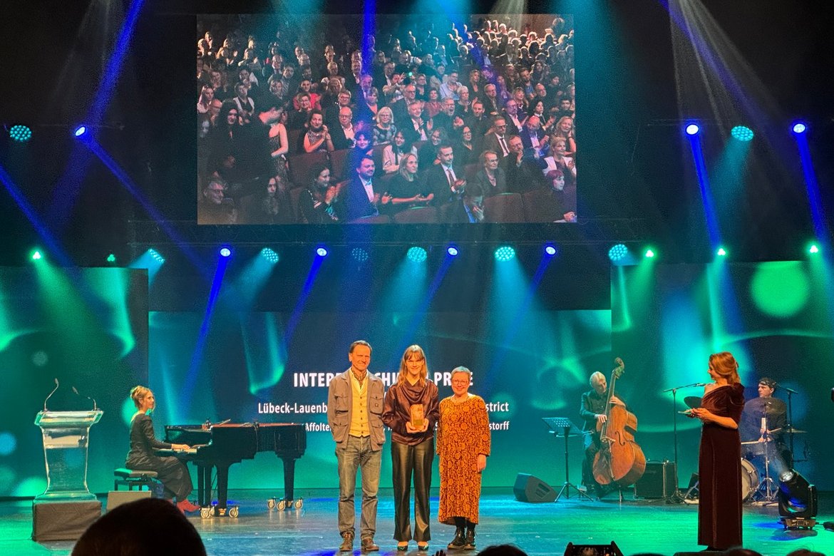 drei Menschen stehen auf der Bühne im Theater Lübeck.