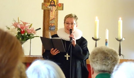 Eine Frau spricht in einer Kirche