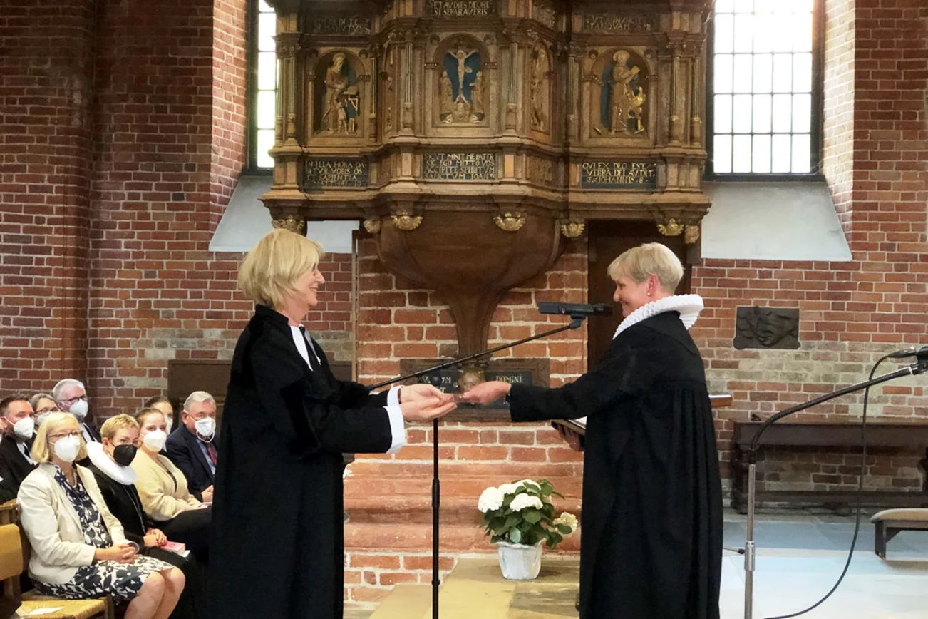 Übergabe des Pröpstinnen-Kreuzes. Im Hintergrund die Kanzel im Ratzeburger Dom.