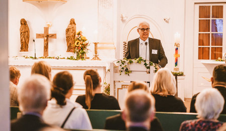 Ein Mann hält eine Rede am Podium.