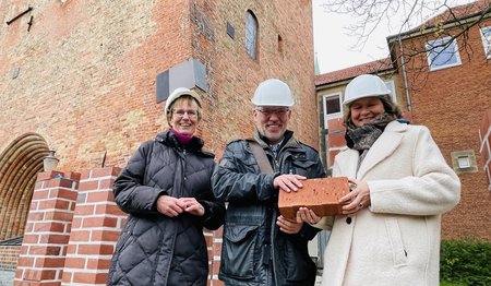 Personen stehen vor einer Kirche